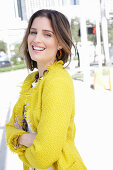 A young woman wearing a yellow bouclé jacket