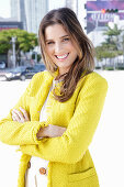 A young woman wearing a yellow bouclé jacket