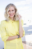 A blonde woman wearing a frilly yellow blouse