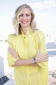 A blonde woman wearing a frilly yellow blouse