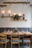 Arrangement of dried flowers suspended over table set for wedding in Industrial-style interior