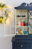 Christmas decorations and fairy lights in old kitchen dresser with open door