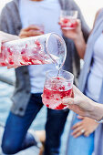 Cranberry-Granatapfel-Eistee wird in Glas gegossen