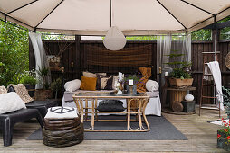 Comfortable, vintage-style seating area under pavillion on terrace