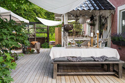 Dining table, bench and vintage-style accessories on large terrace