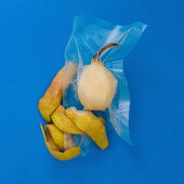 A peeled pear vacuum-packed in a plastic bag