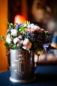 Blumenstrauß mit Baumwollkapseln in silbernem Pokal