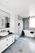 Freestanding bathtub in elegant bathroom in grey, black and white