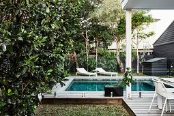 Swimming pool surrounded by wooden deck in garden