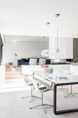 Dining table in open-plan interior with steps leading to living room