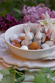 Porcelain Easter bunnies between marzipan eggs in bowl