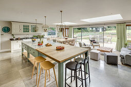 Country-house kitchen and seating area below skylights and glass sliding doors leading to terrace