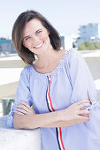 A young woman wearing a blue-and-white striped Carmen blouse