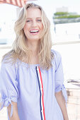 A young blonde woman wearing a blue-and-white striped Carmen blouse