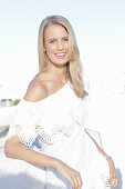 A young blonde woman wearing a Carmen blouse with crochet detail