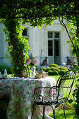 Romantically set tea table in summery château garden