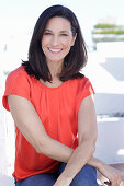 A mature brunette woman wearing a red blouse