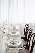 Bistro chairs around table set with lace tablecloth