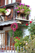 Wreath of rose hips and amaranth hung from Alpine-style balcony