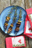 Colourful potatoes grilled on sprigs of rosemary and decorated napkins