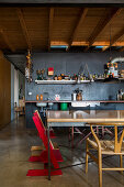 Küche und Essbereich im Loft mit Holzdecke und schwarzer Wand