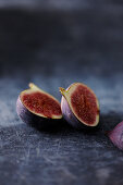 Two fig halves on a gray background