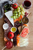 Vorspeisenplatte mit Salami, Käse, Obst, Gemüse, Brot und Wein