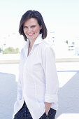 A young woman wearing a white shirt and polka dot trousers