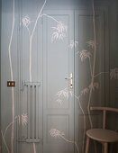 Door, wall and radiator painted grey and decorated with stencilled bamboo branches