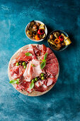 Cold cuts with olives and marinated vegetables in small bowls