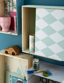 Shallow shelving modules covered in wallpaper with various patterns on wall