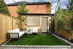 Lawn and outdoor sofa in small garden of terraced house