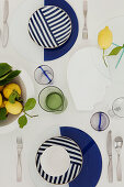Gedeckter Tisch mit blau-weißem Geschirr dekoriert mit Zitronen