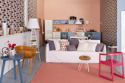 Wallpaper with graphic patterns and kitchen counter against pink end wall in eclectic open-plan interior