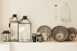 Glass lanterns and black-and-white patterned ceramics on ledge