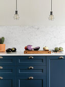Vegetables on blue kitchen counter with marble worktop