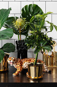 Leopard figurine and exotic plants in golden cache pots