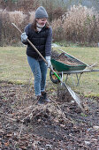 Woman raking up garden waste