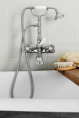 Vintage-style tap fittings over bathtub with bath caddy