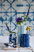 Anemone, veronica and drumstick flowers in blue vessels
