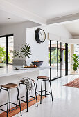 Marble breakfast bar with bar stools in white, open-plan interior