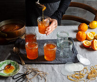 Preparing orange jam from Seville oranges: pouring jam into glasses