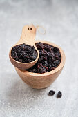 Currants in a wooden bowl and a wooden scoop