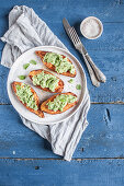 Oven baked sweet potatoes stuffed with guacamole and sprinkled with fresh mint
