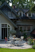 Garden table on paved terrace outside rustic house