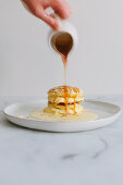 Pouring caramel sauce over Japanese soufflé pancakes