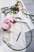 Pink carnations tied to metal ring with ribbon