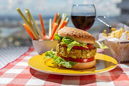 Homemade healthy vegan green lentil burger with tomato, lettuce and french fries with glass of red wine