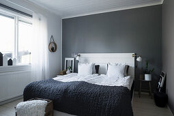Schlichtes Schlafzimmer in Grau und Weiß mit Betthaupt aus Brettern