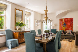 Blue loose-covered chairs around set dining table in classic interior